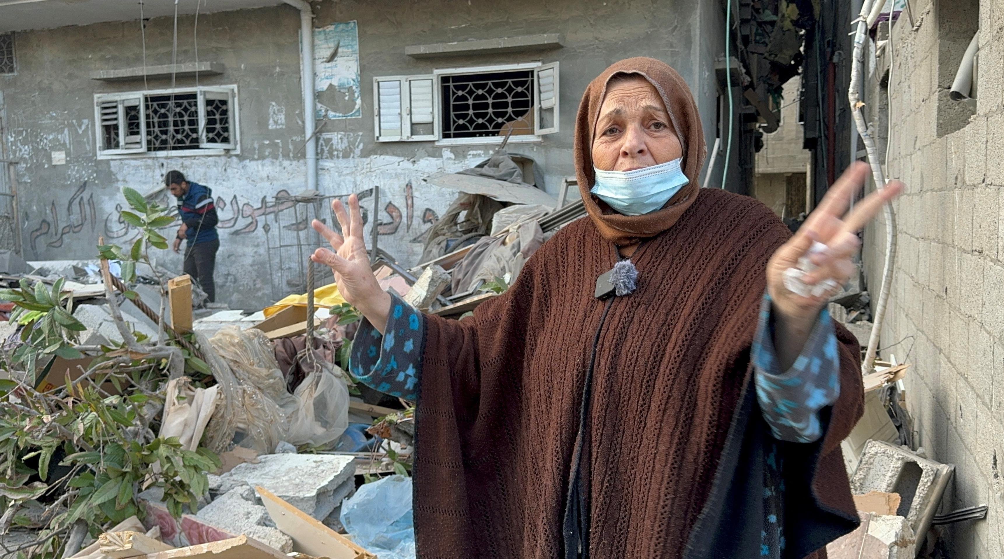 امرأة فلسطينية تشير إلى موقع غارة إسرائيلية على منزل في خان يونس وسط الصراع المستمر بين إسرائيل وحركة حماس.