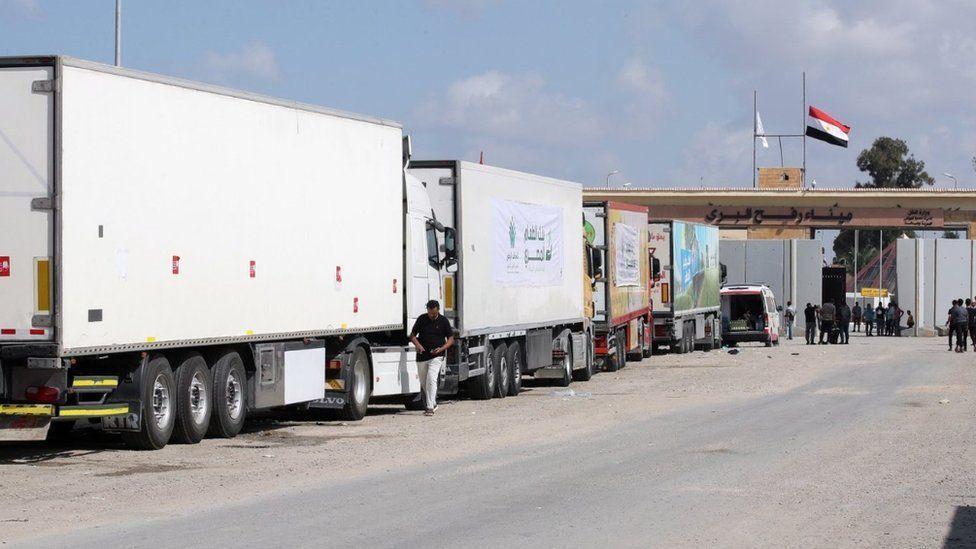 Los camiones de un convoy de ayuda humanitaria están estacionados frente a la puerta fronteriza en Rafah, Egipto, el 19 de octubre de 2023.