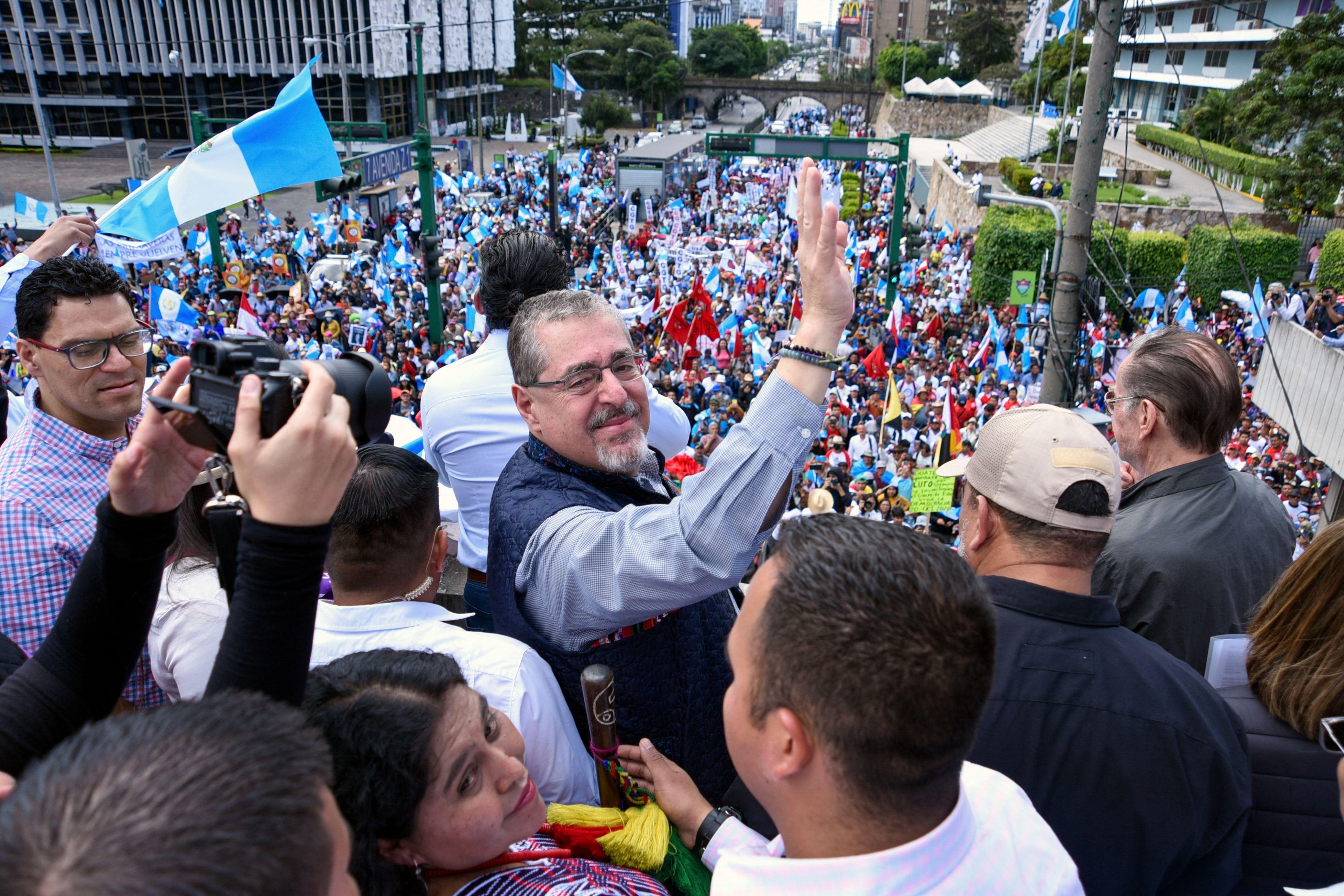 Bernardo Arévalo saluda en un acto rodeado de gente.