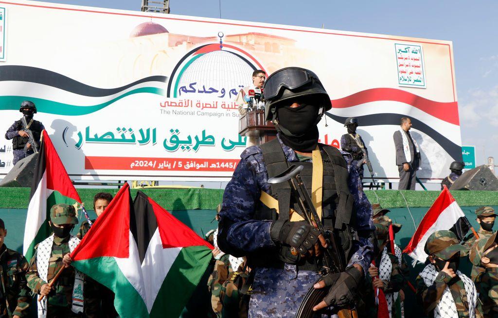 يمنيون يرفعون الأعلام الفلسطينية واليمنية في حراسة الجنود في 5 يناير/كانون الثاني 2024