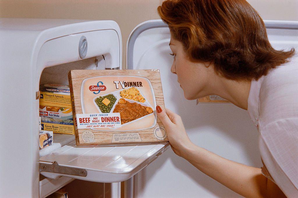 Mujer sacando del congelador una "cena de TV" Swanson en 1950.