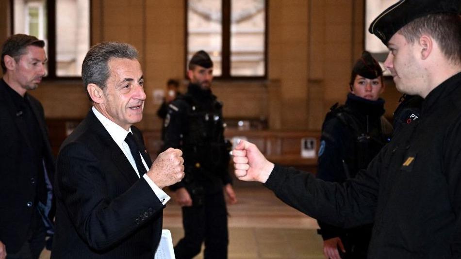 Sarkozy fazendo cumprimento de mão com guarda