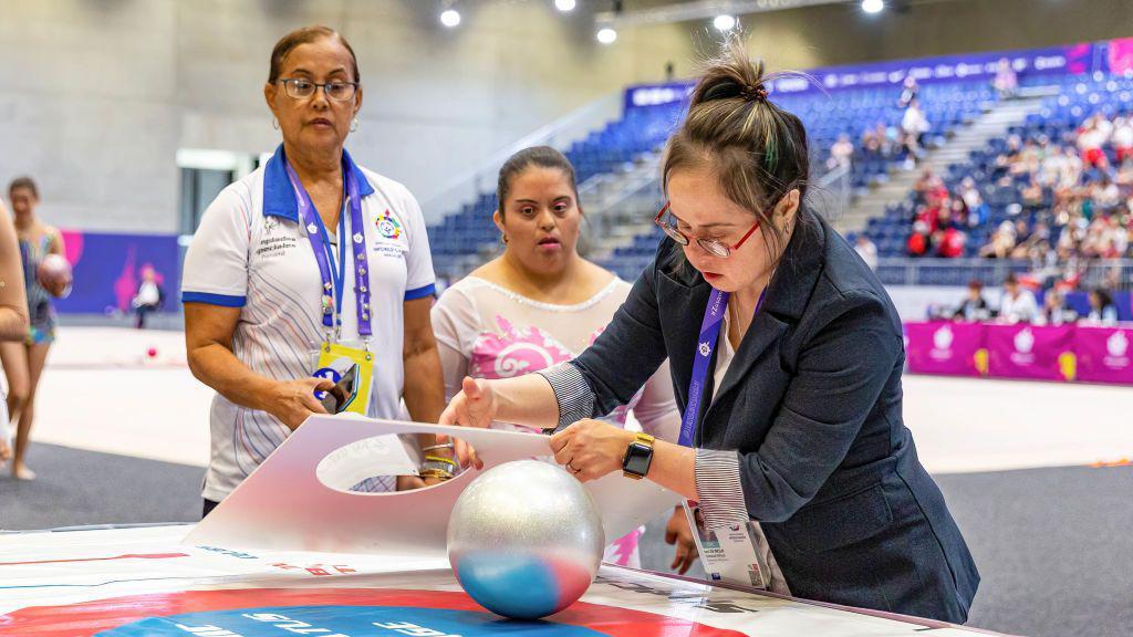 An olympic officer with down syndrome provides equipment check of an athlete after competition in Rhythmic Gymnastics sport discipline during the Special Olympics Summer World Games Berlin 2023 in Messe conference centre.