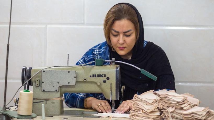 An Iranian woman working as a seamstress in a lingerie factory in Tehran