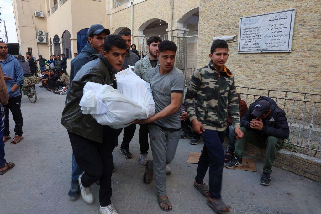 Varias personas cargan una víctima de uno de los ataques aéreos de Israel desde el hospital Al Mamdani en la ciudad de Gaza, en la Franja de Gaza, el 28 de marzo de 2025. (Foto: Omar AL-QATTAA / AFP vía Getty Images)