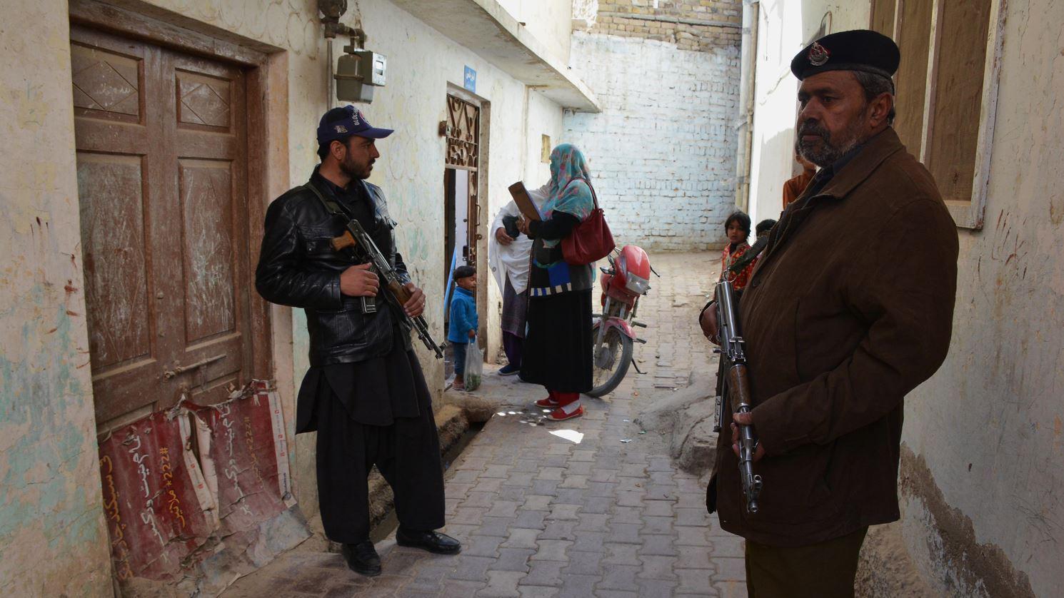 Pakistani policemen escort a team of polio health workers during a polio vaccination campaign in Quetta