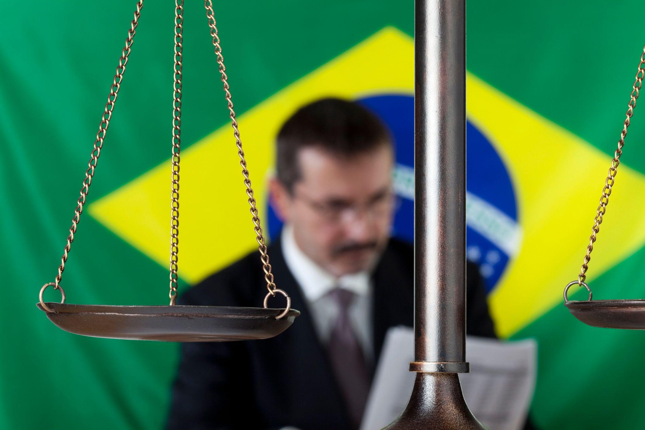 Homem em frente a bandeira do Brasil