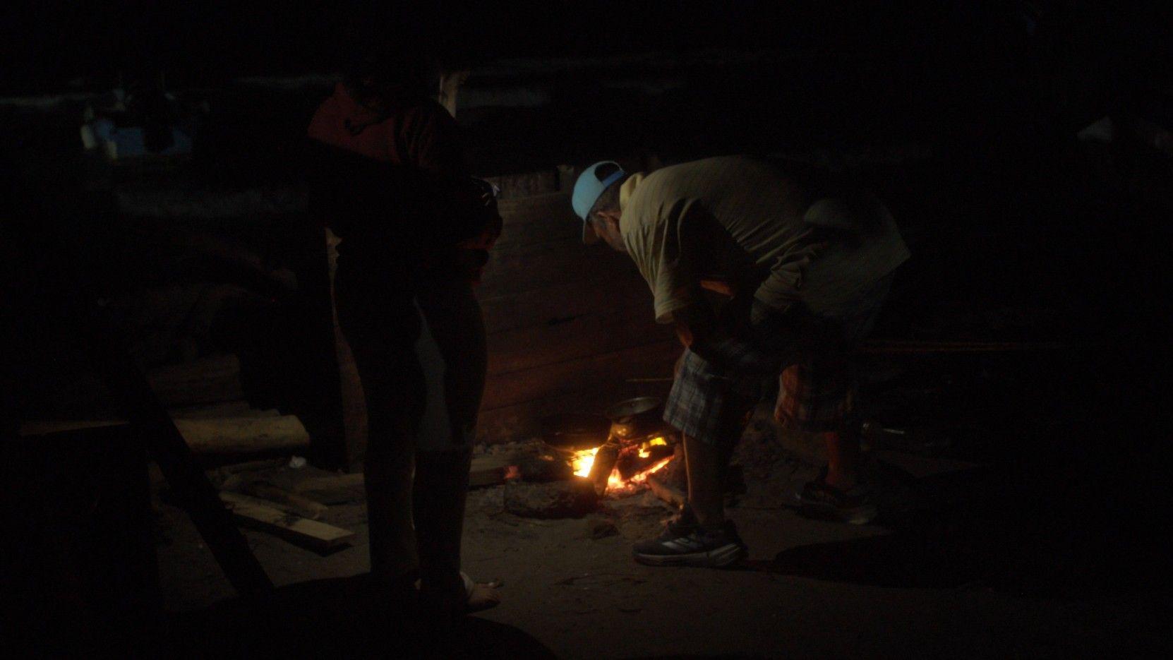 Migrantes venezolanos junto a una fogata en la playa de Necoclí. 