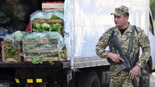 Un soldado patrulla por uno de los agromercados impulsados por el gobierno de Bukele.