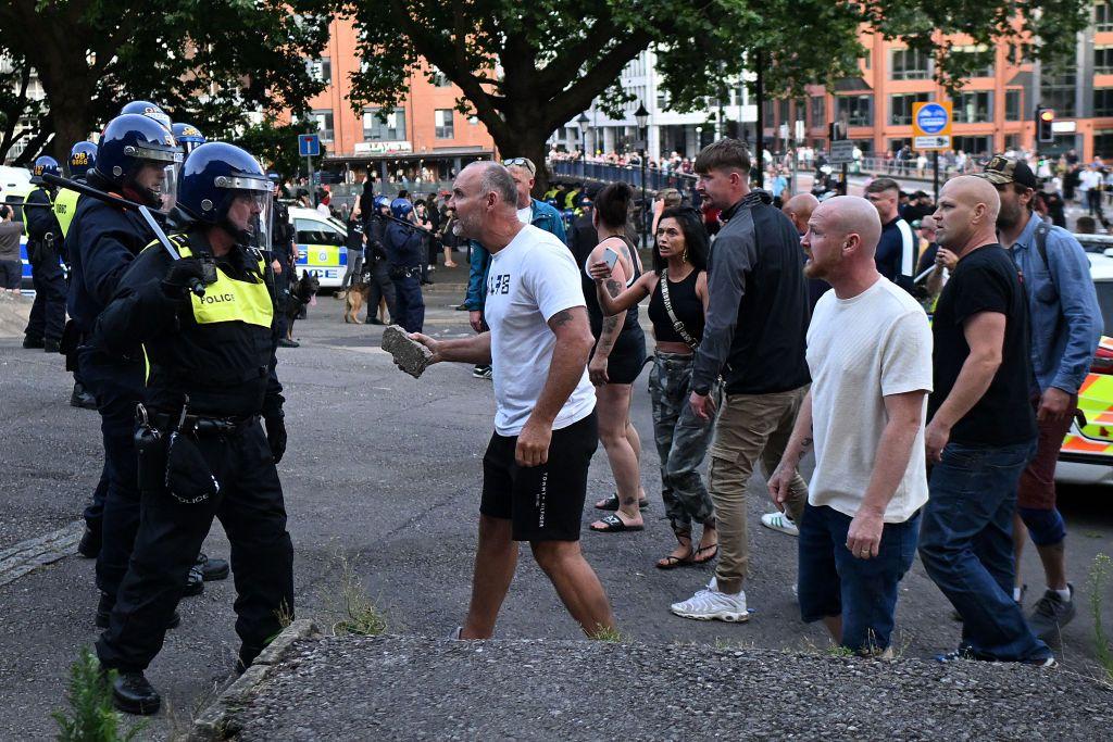 Seorang pengunjuk rasa berjalan menuju polisi anti huru-hara saat bentrokan terjadi di Bristol pada 3 Agustus 2024 