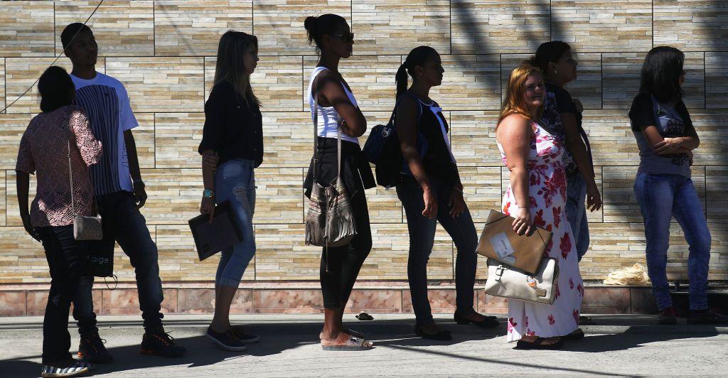 Fila de pessoas com pastas na mão 