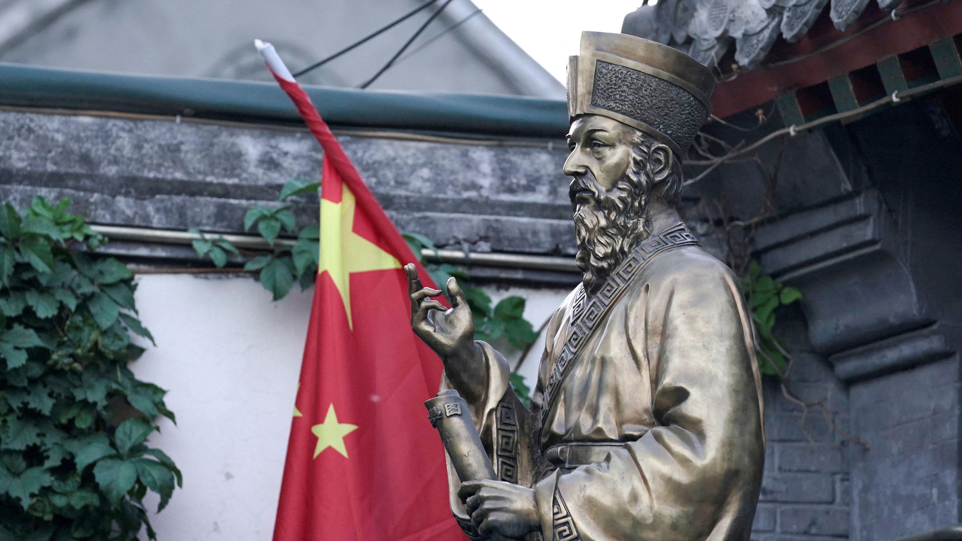 Bendera Tiongkok terlihat di sebelah patung Jesuit Italia Matteo Ricci, pembangun gereja pertama pada masa Dinasti Ming, di pintu masuk Gereja Katolik Selatan Beijing. Gereja ini adalah gereja Katolik yang direstui pemerintah, di Beijing, China (foto arsip)