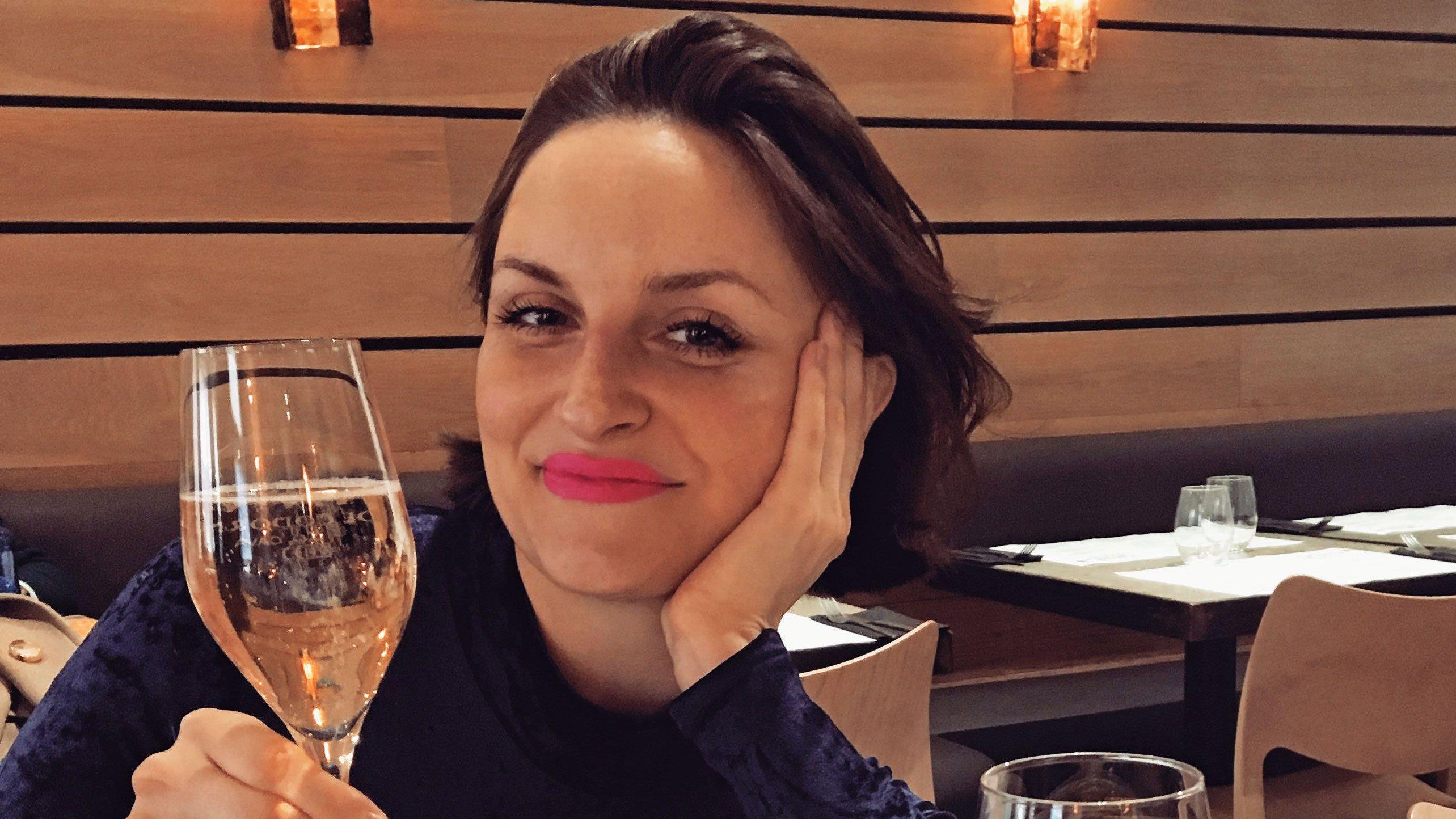 Laura Dockrill sonriendo, con una copa de champán