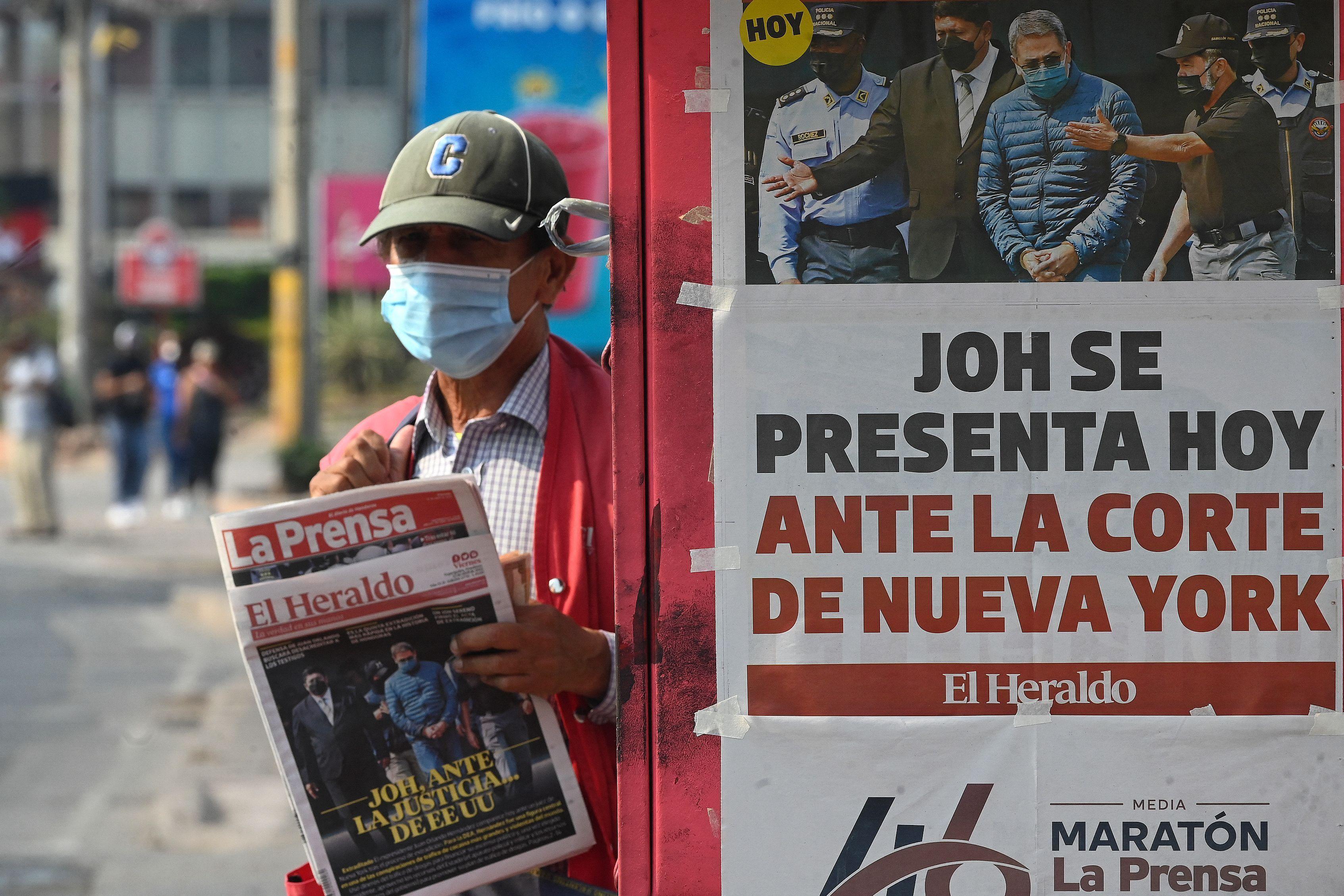Un hombre sujetaun diario en Honduras con la noticia de que el expresidente Hernández se presenta ante la justicia de EE.UU. 