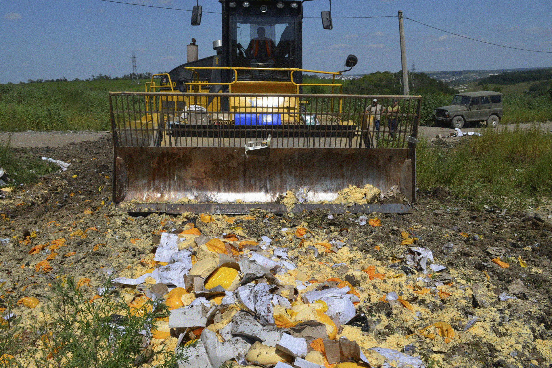 A bulldozer crushing a selection of cheeses