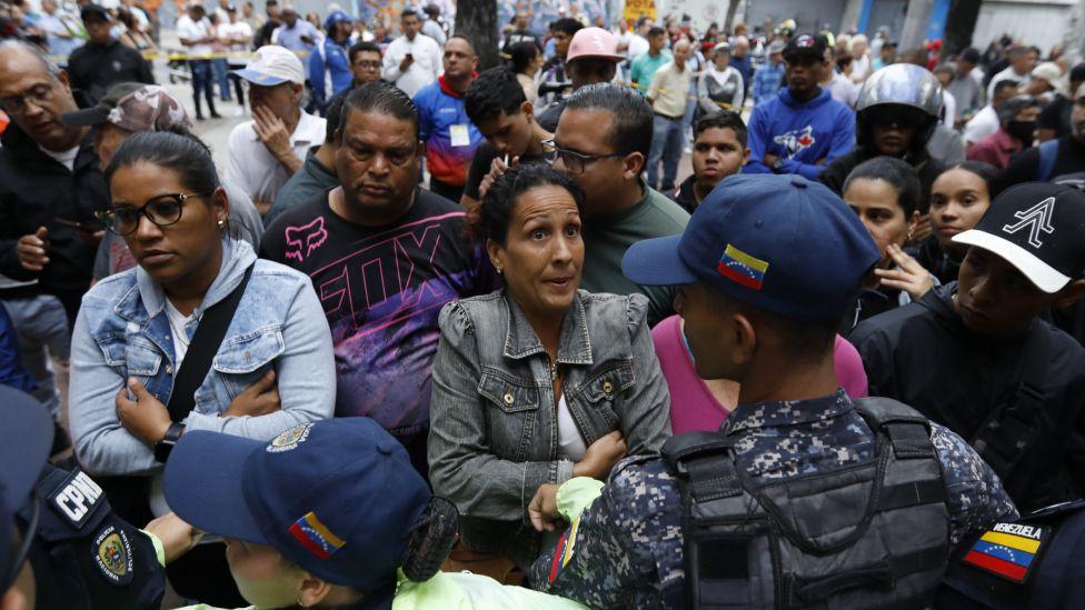 Manifestantes prximos de policiais na Venezuela