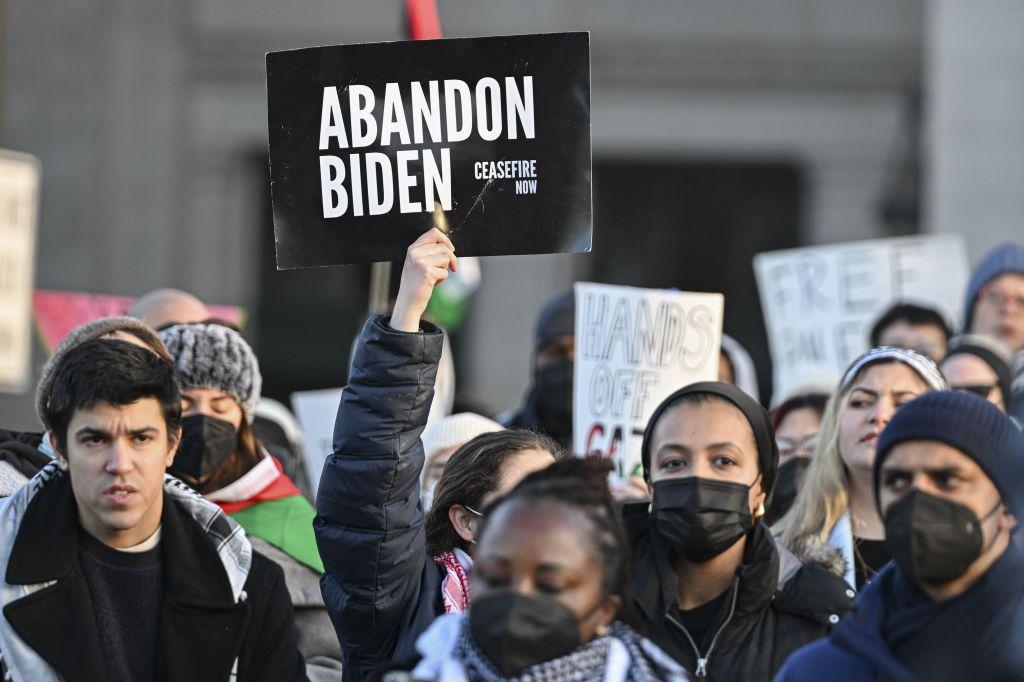 Manifestantes contra la ofensiva israelí en Gaza muestran un cartel que pide "abanonar a Biden". 