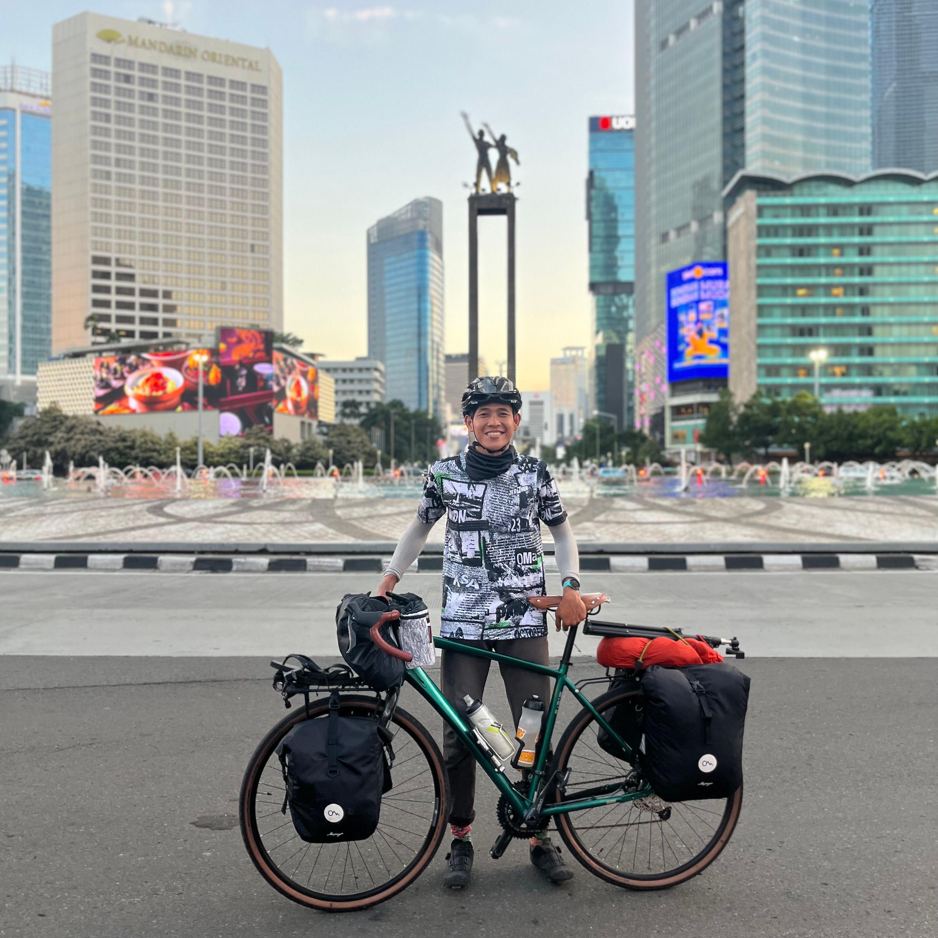 Ari Yami berpose dengan sepedanya di depan Bunderan HI, Jakarta Pusat.