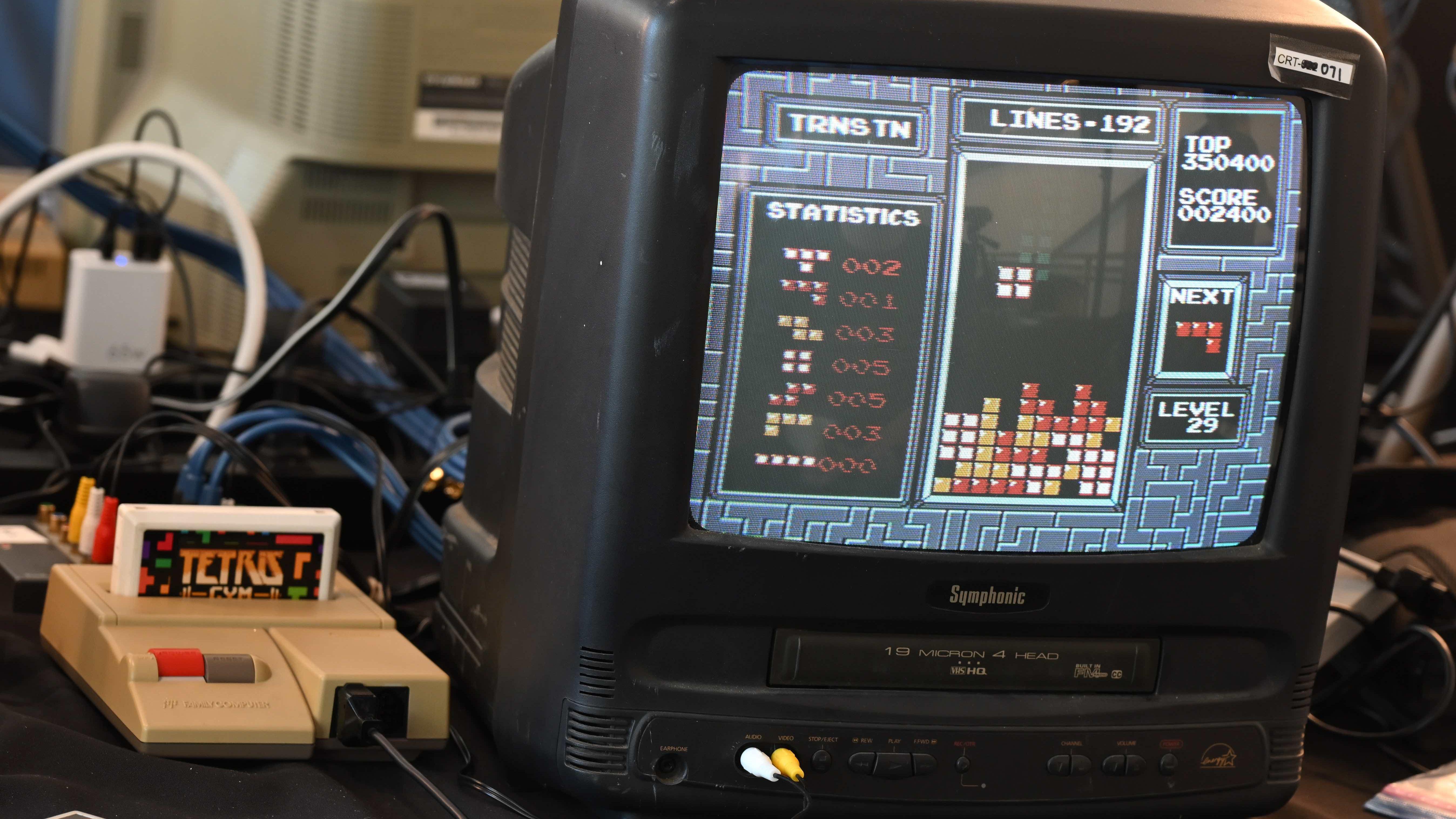 Nintendo gaming console with Tetris cartridge inserted and Tetris on a TV monitor