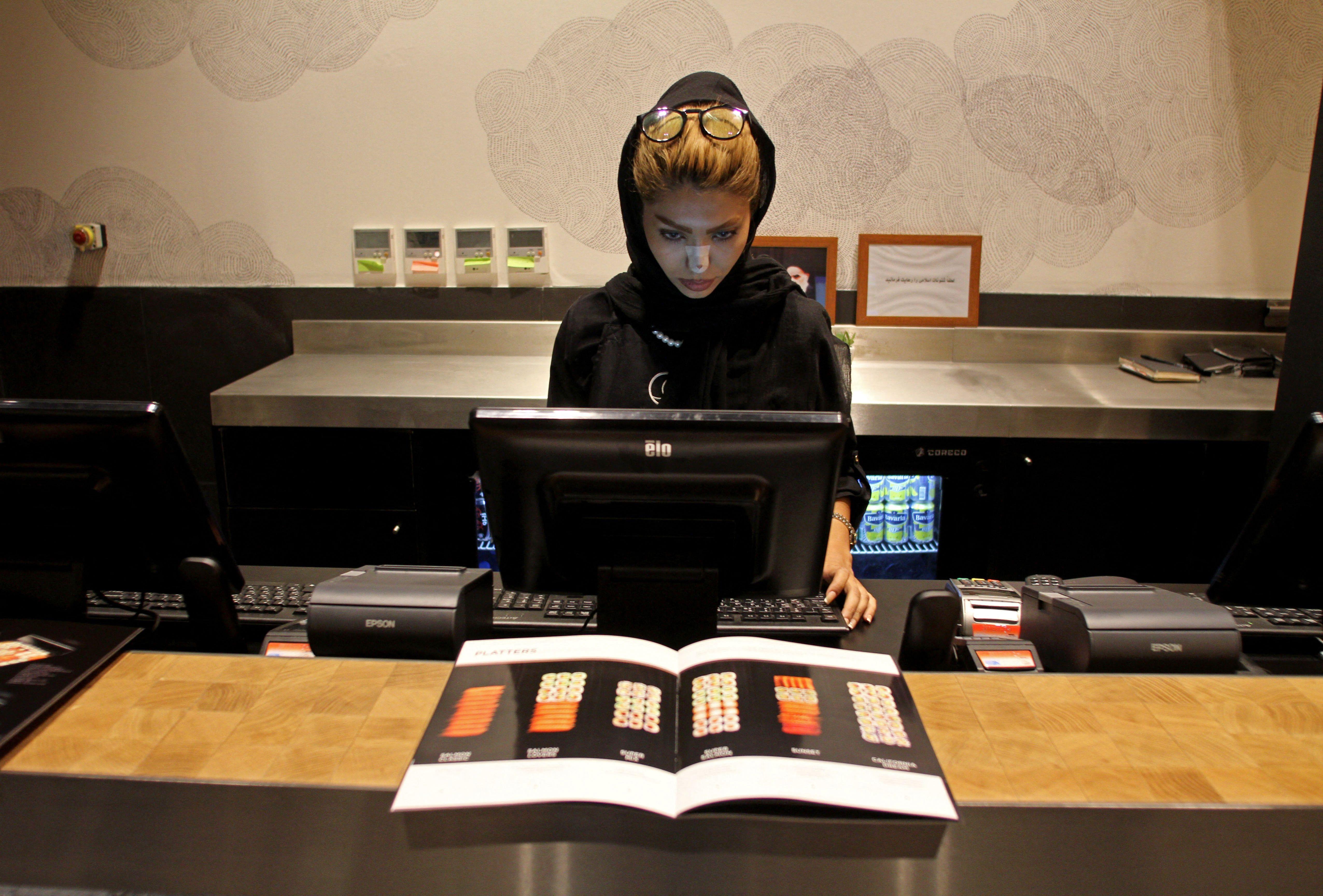 An Iranian woman works behind the counter at a high-end French sushi chain that opened the previous week in northern Tehran in 2017