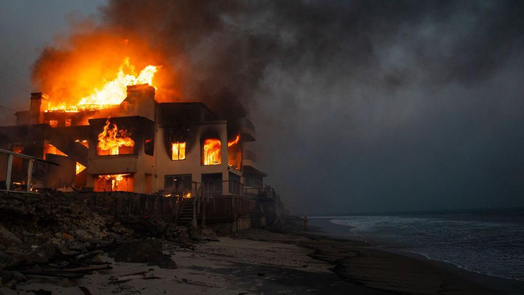 Casa pegando fogo de frente para o mar