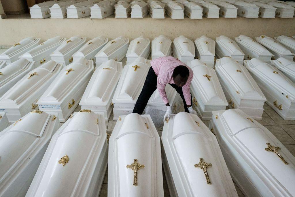 رجل يضع توابيت مع رفات ضحايا الإبادة الجماعية في رواندا عام 1994 قبل الدفن الجماعي في النصب التذكاري للإبادة الجماعية في نيانزا في كيغالي في 2 مايو/ أيار 2019.