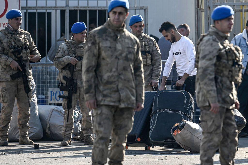جنود أتراك على الحدود مع سوريا ينظمون عودة لاجئين سوريين إلى بلادهم بعد إطاحة المعارضة السورية بحكم بشار الأسد.