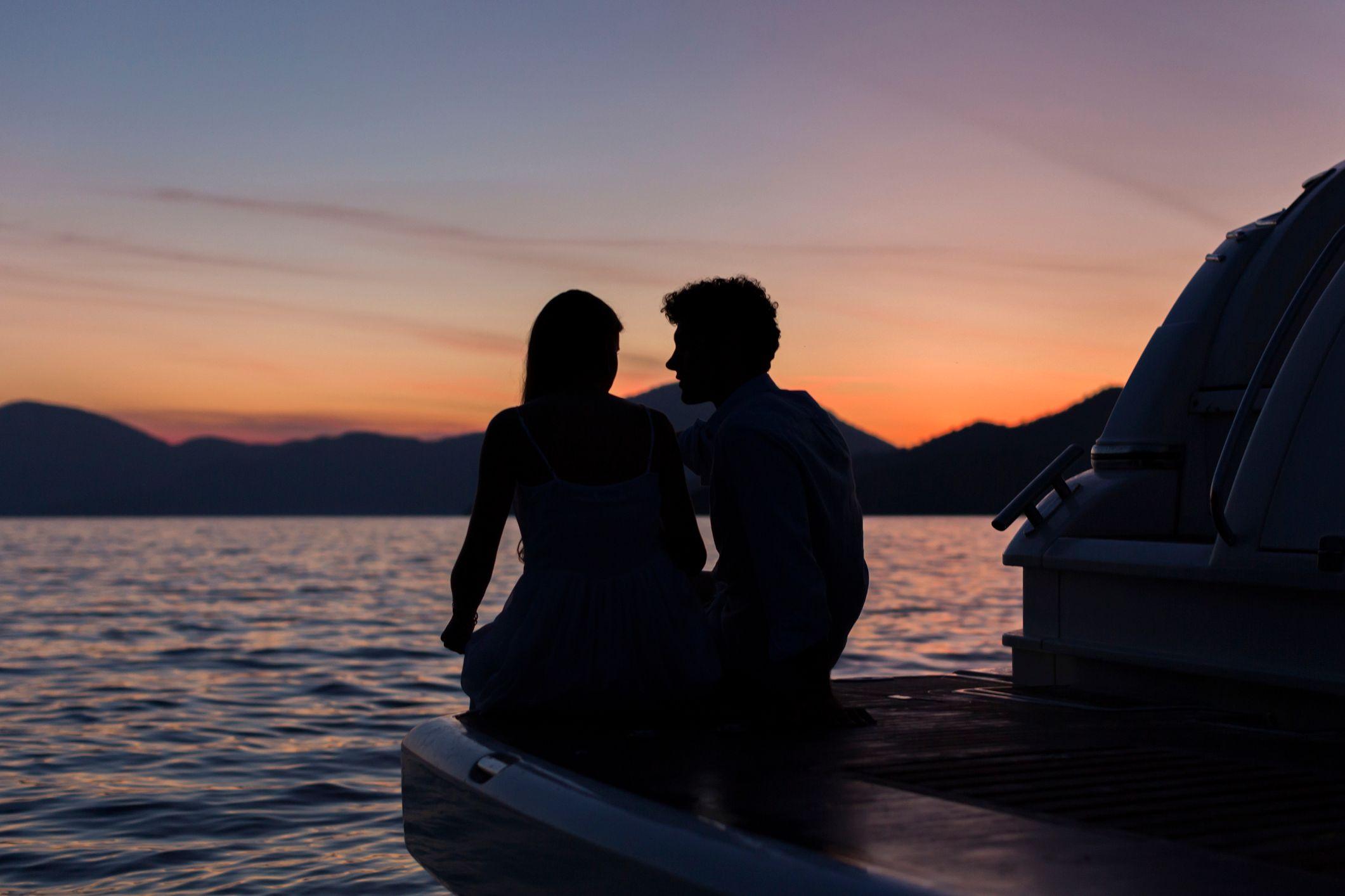 Casal em praia olhando o entardecer