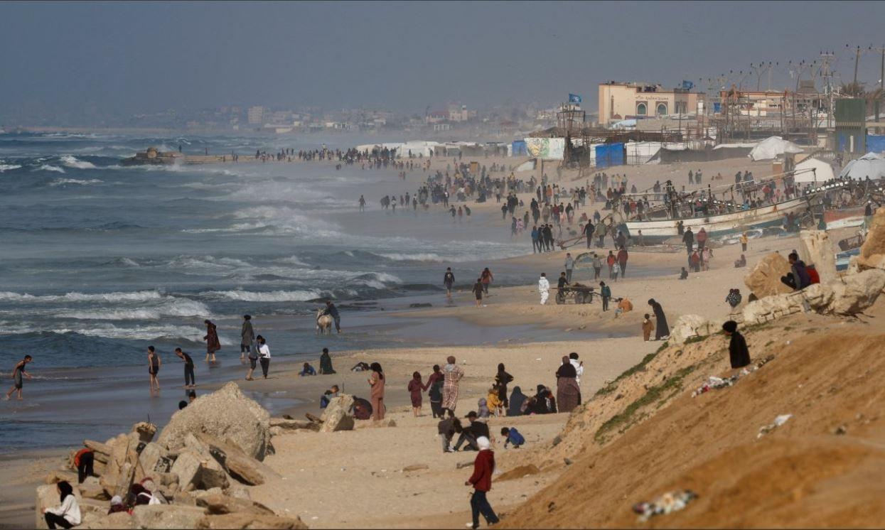 فلسطينيون يتجمعون على الشاطئ على أمل إسقاط المساعدات جوا فوق غزة، وسط الصراع المستمر بين إسرائيل وحماس، في جنوب قطاع غزة، 27 فبراير، 2024. رويترز/محمد سالم