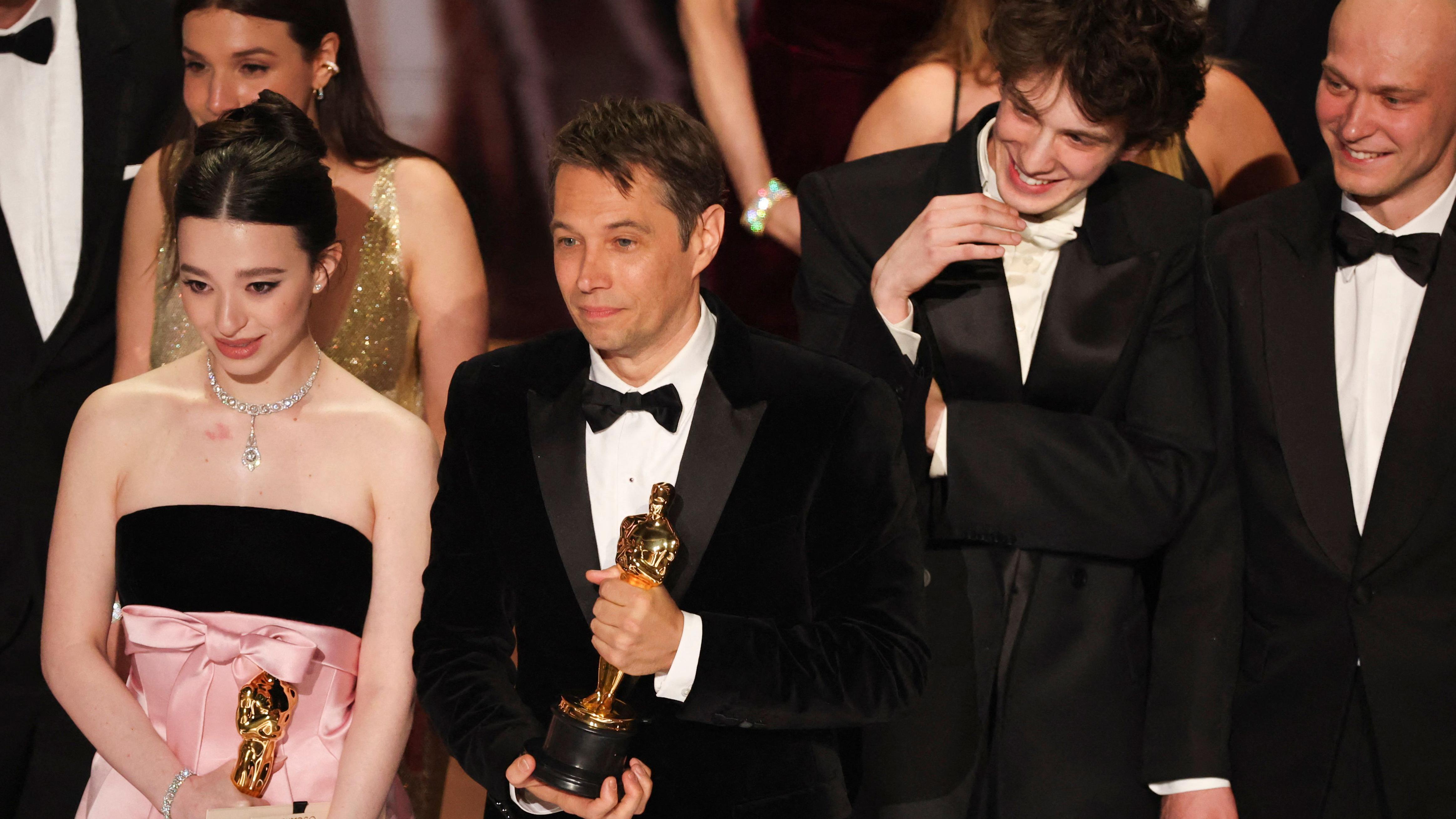 Mark Eydelshteyn, Yura Borisov y la ganadora del premio a la Mejor Actriz, Mikey Madison, junto al director Sean Baker en el escenario después de que "Anora" ganara el Premio a la Mejor Película durante la gala de los Oscar en la 97ª edición de los Premios de la Academia en Hollywood, Los Ángeles, California, Estados Unidos, el 2 de marzo de 2025.