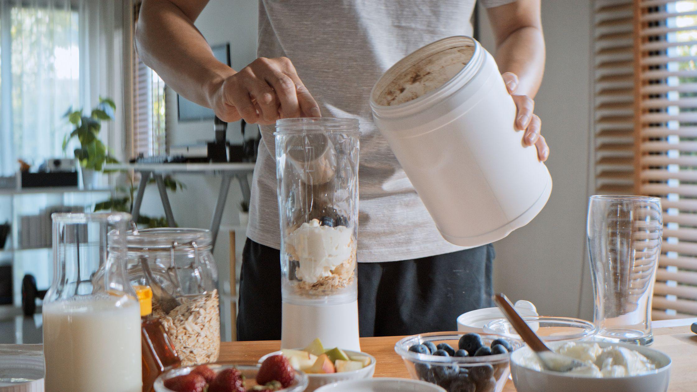 persona mezcla proteína en polvo con varios alimentos 