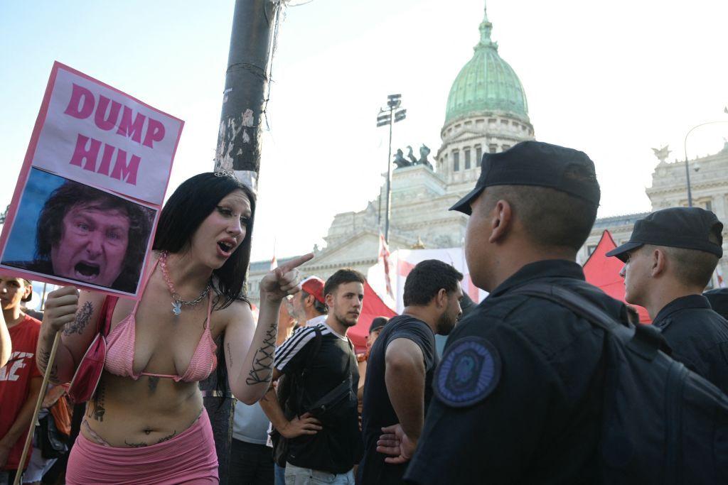 Una trabajadora sexual con una pancarta frente a agentes de la policía frente al Congreso mientras los legisladores debaten el "proyecto de ley general" de reformas económicas del gobierno en Buenos Aires el 1 de febrero de 2024. 