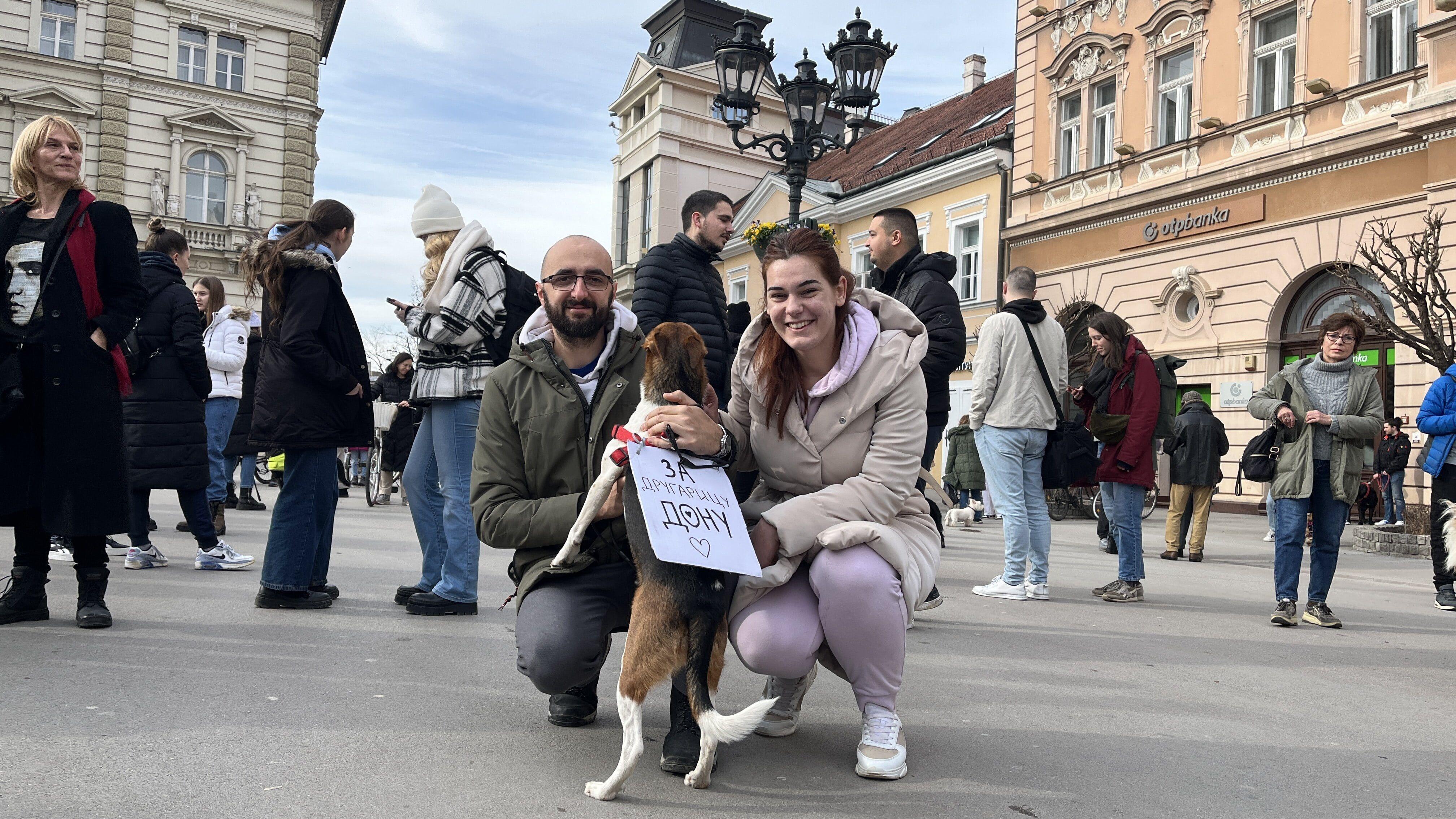 Dvoje ljudi sa psom u sredini