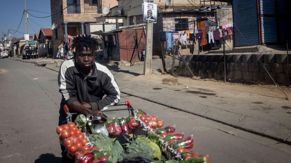 Sul-africanos vendendo verduras na rua.