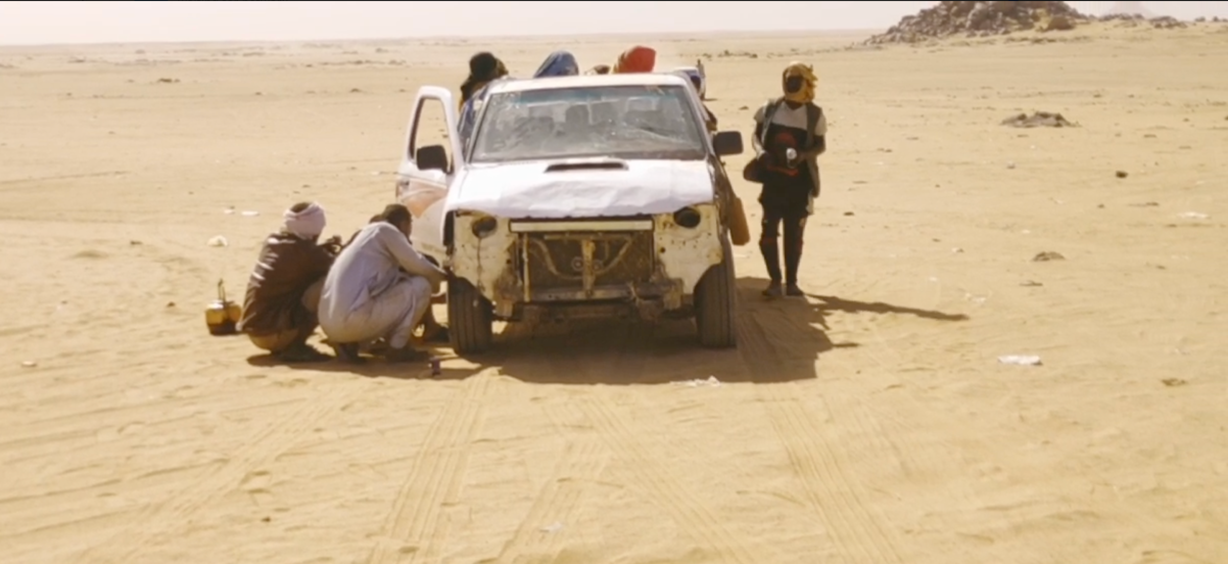 SUV rodeado de pessoas em um deserto