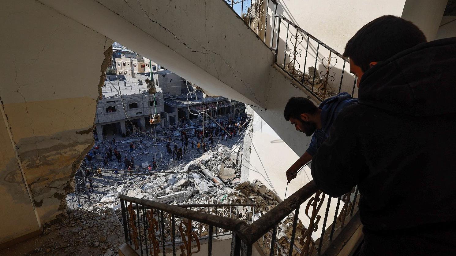 شابان في عمارة مدمرة جراء القصف الإسرائيلي في غزة