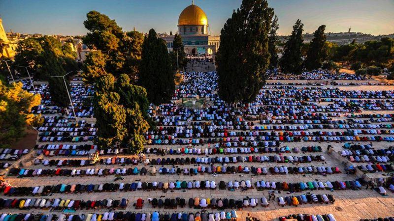 Muçulmandos orando em frente à mesquita de Al-Aqsa