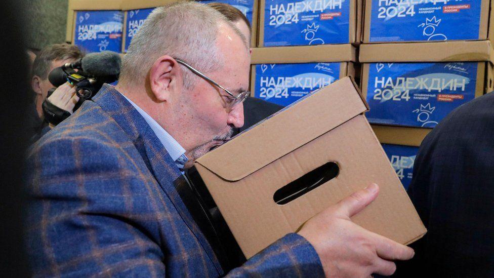  Nadezhdin besa una de las cajas que tienen las firmas que avalan su candidatura. 
