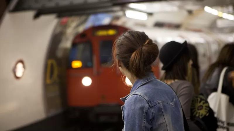 Mulher observando a chegada de um trem