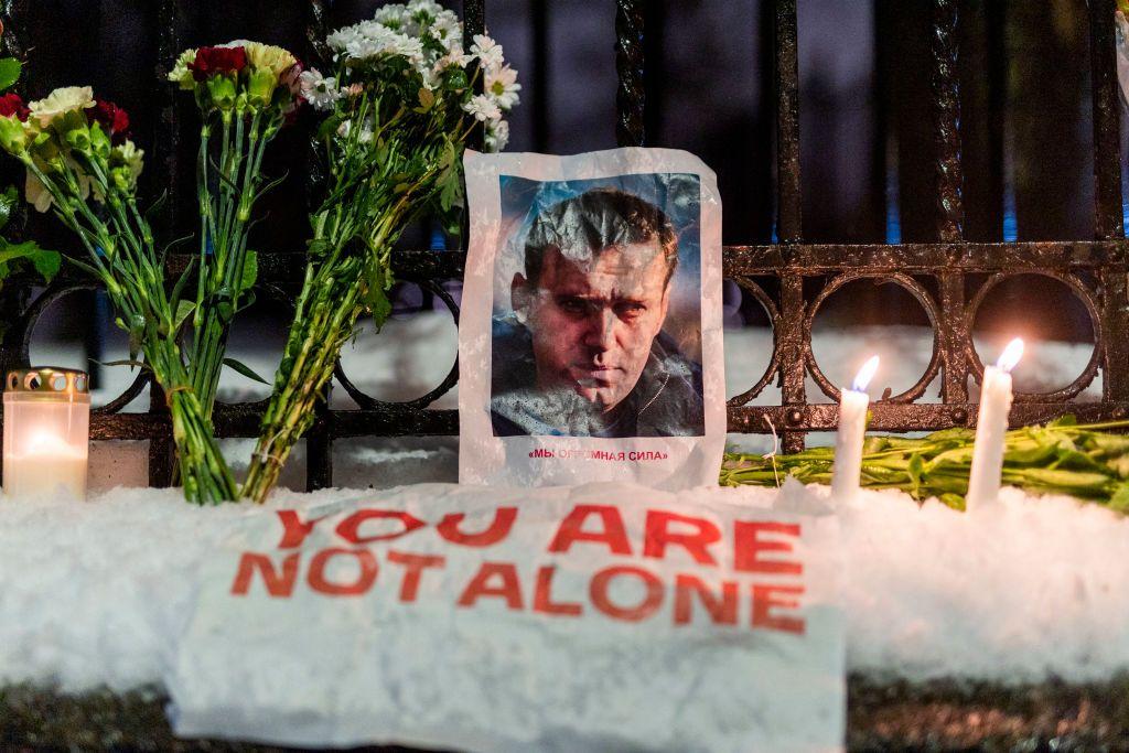 Un cartel con la cara de Nalvany junto a unas velas y unas flores en Ucrania