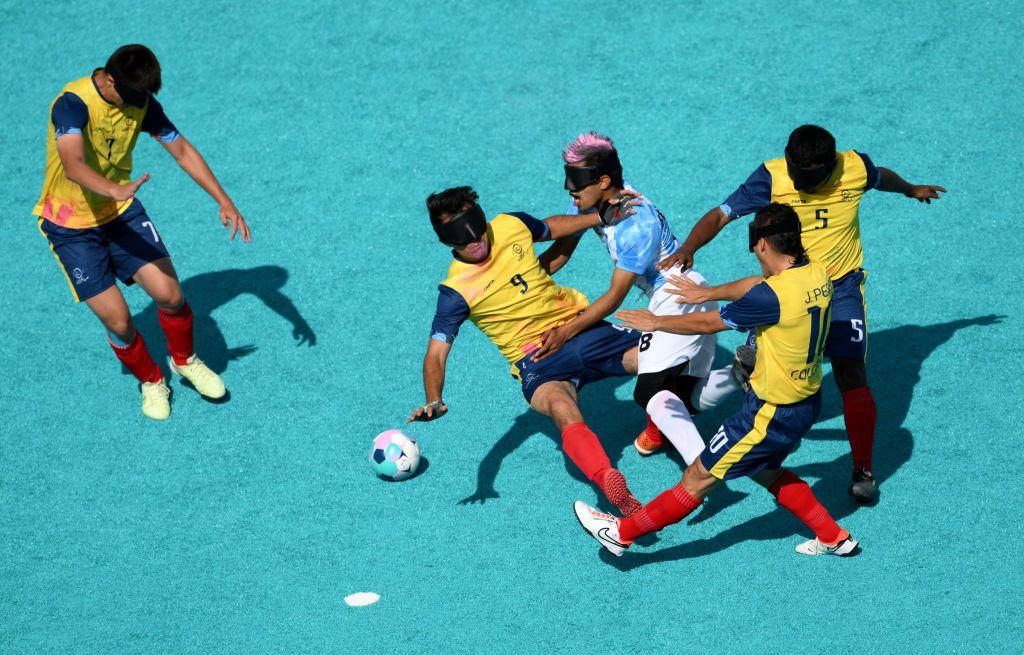 Jugador de Argentina se enfrenta a varios rivales de Colombia en un partido de fútbol para ciegos en París 2024. 