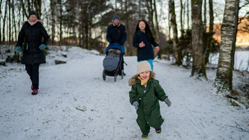 Família passeando num bosque com neve