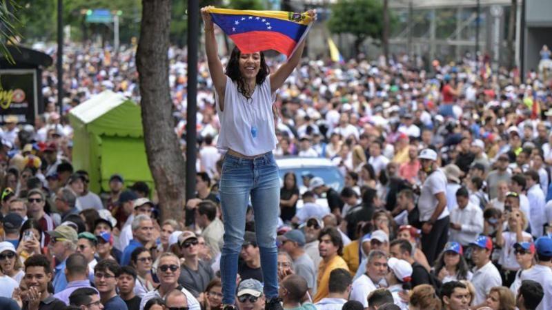 Jovem segura bandera da Venezuela em protesto