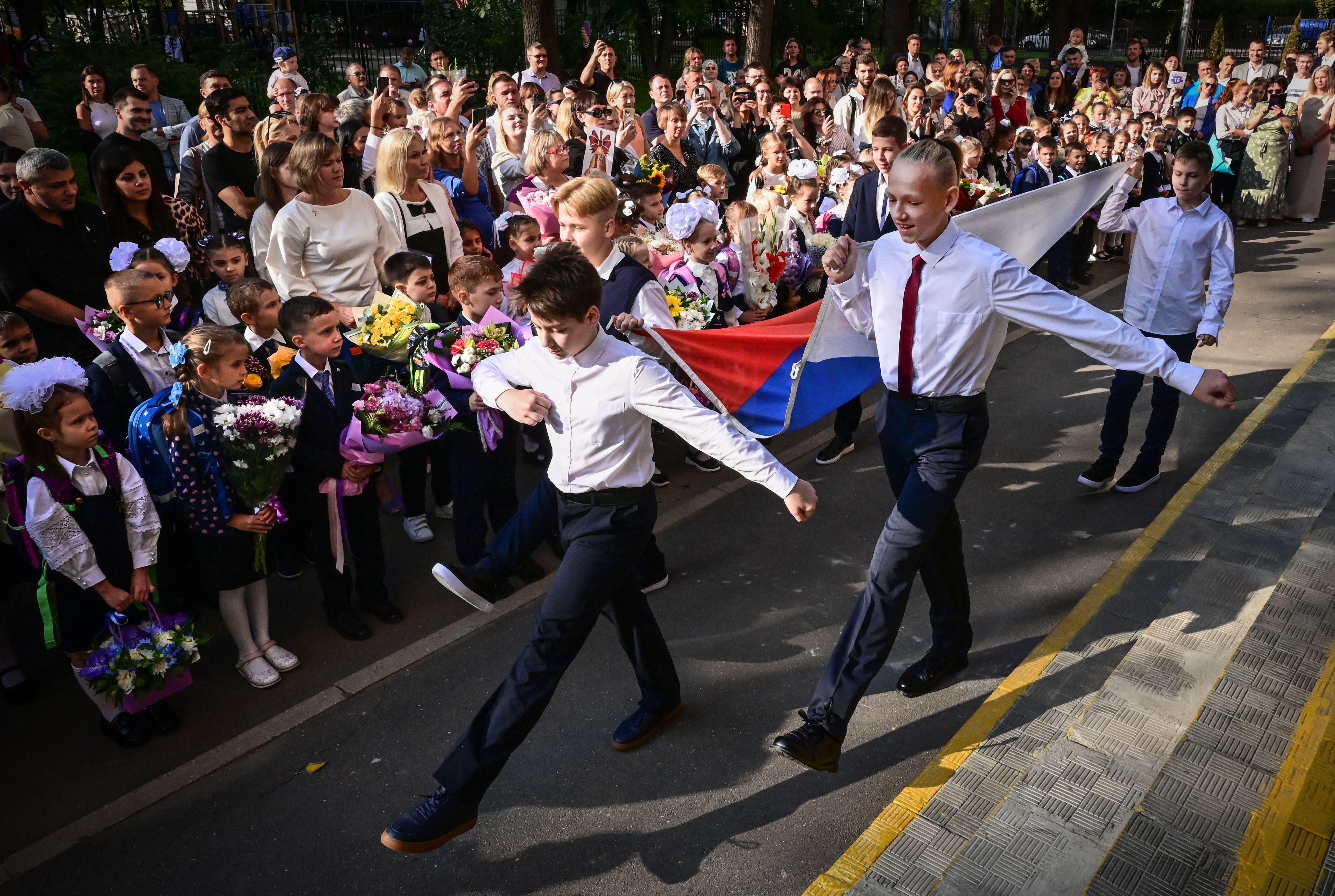 Desfile de alunos no início do ano letivo em uma escola de Moscou