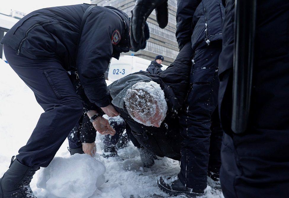 Hombre con nieve al ser detenido por policías