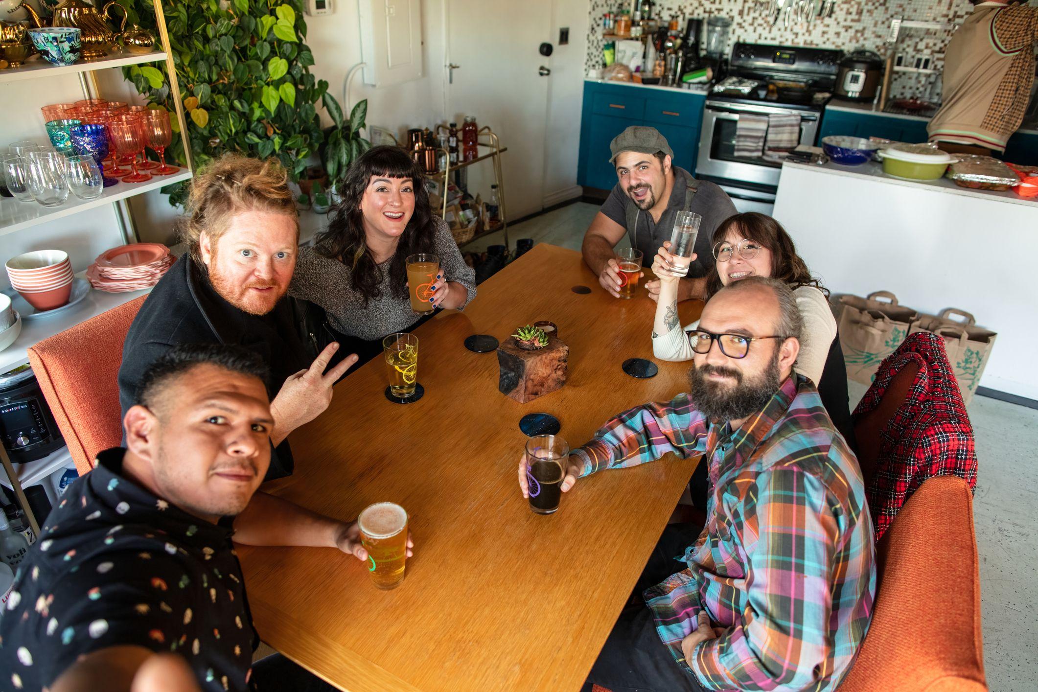 Pessoas reunidas em volta de uma mesa dentro de uma casa