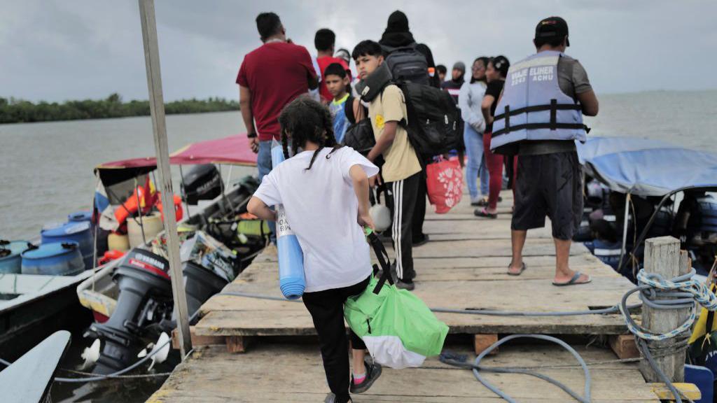 Migrantes venezolanos en una lancha en Puerto Carti