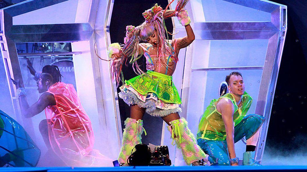 Lady Gaga dançando com roupa colorida durante turnê