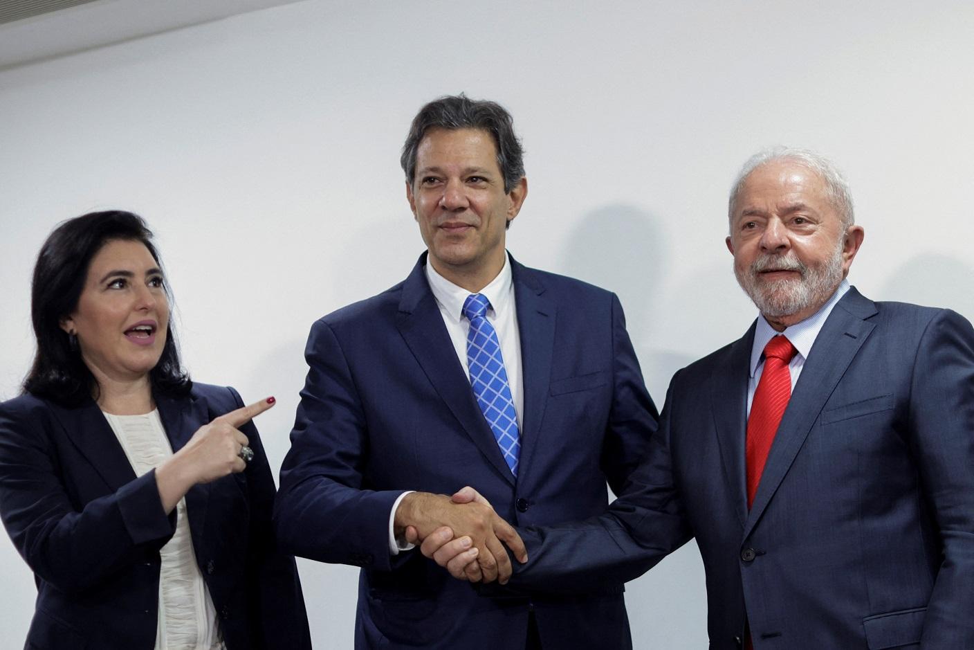 Simone Tebet, Fernando Haddad e Lula posando para foto em pé