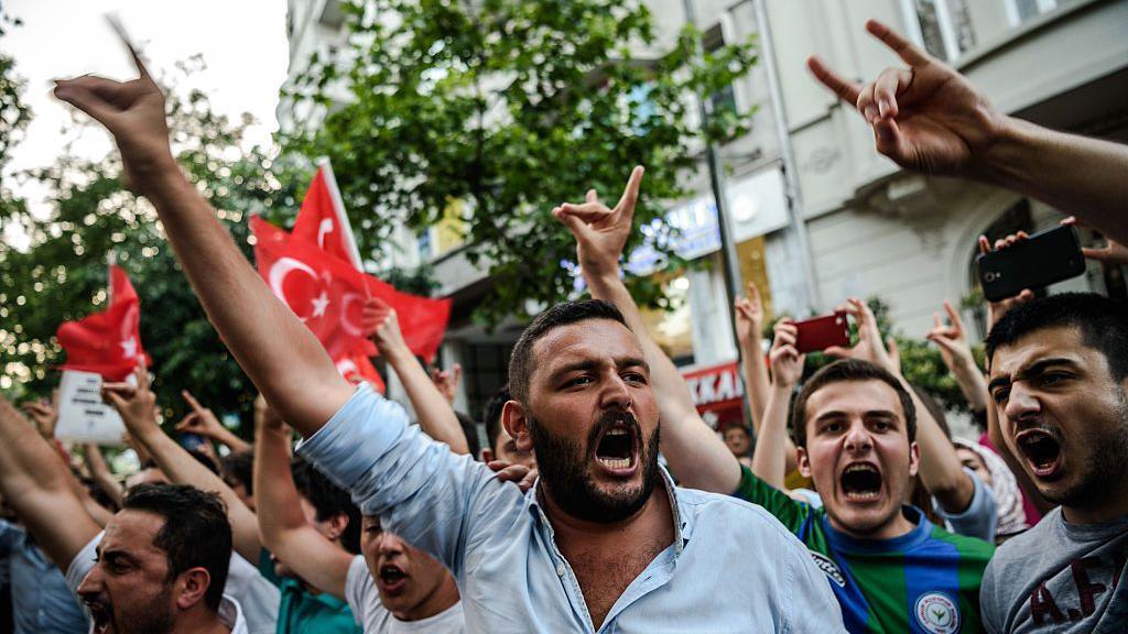 Homens fazendo o gesto do lobo em um protesto em Istambul